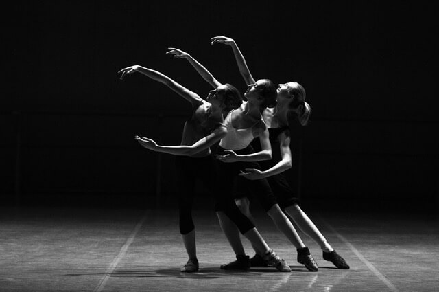 Mouvement gracieux de trois danseuses sur fond noir